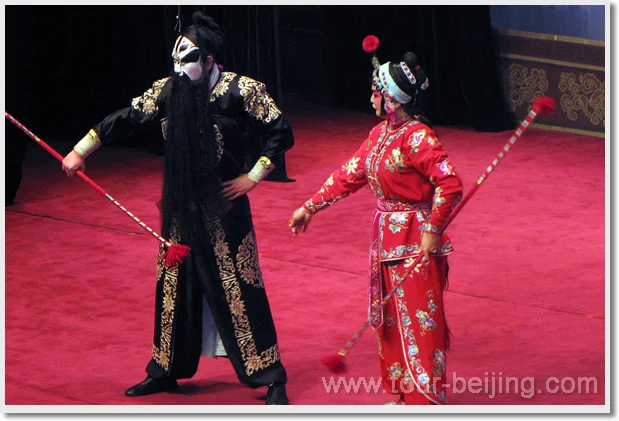 Two costumed Peking opera performers holding stage staffs
