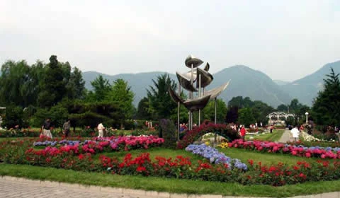 Flower beds and sculpture with hills behind Beijing Botanical Garden