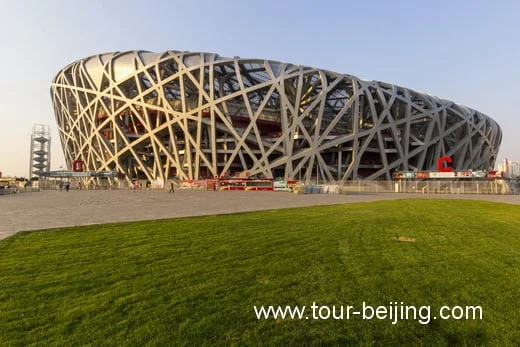 Beijing National Stadium with its interlaced steel exterior above a lawn