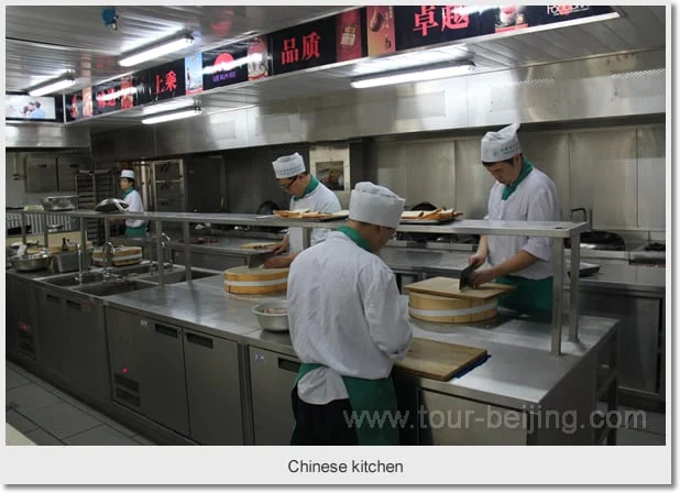 Cooks preparing ingredients at chopping blocks in a Chinese kitchen